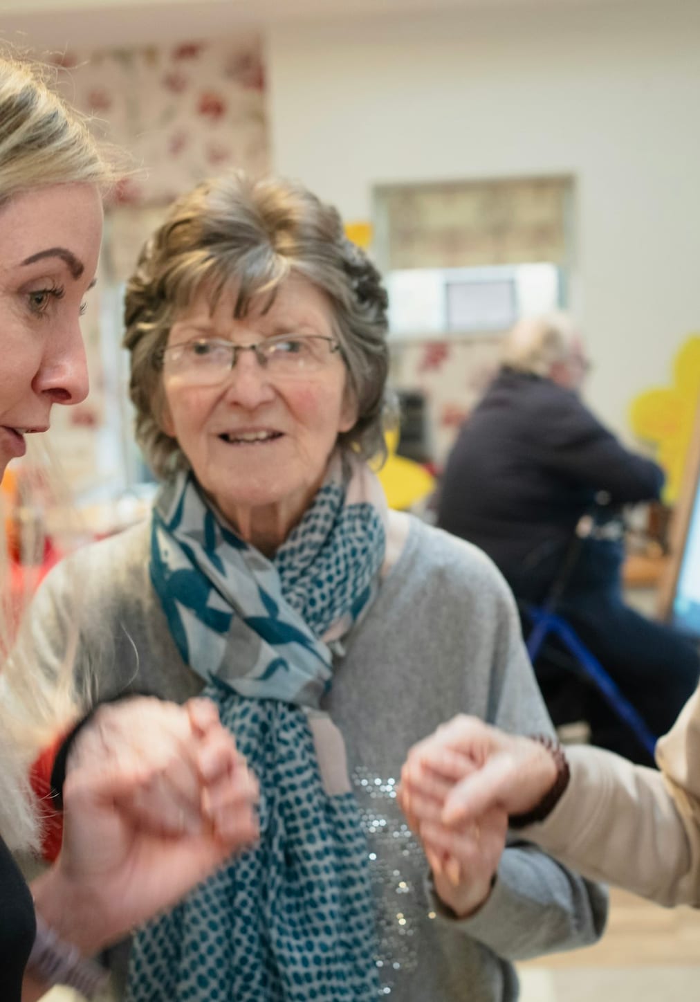 A caregiver in warm conversation with a senior client at home
