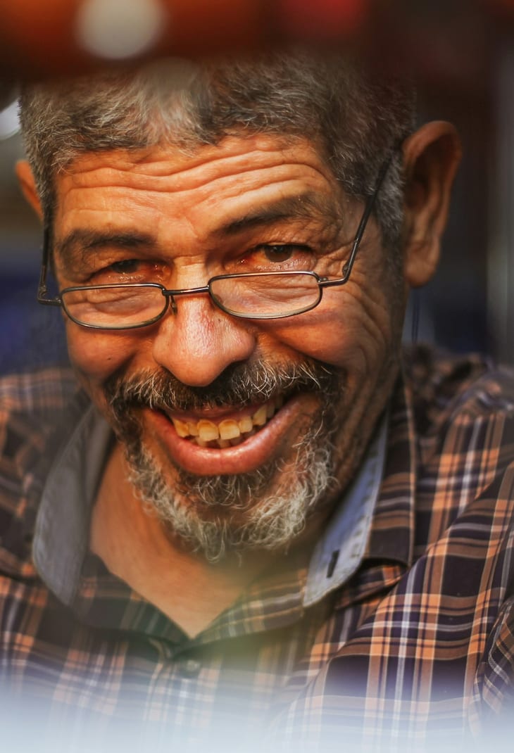 A senior man laughing during a visit from his caregiver